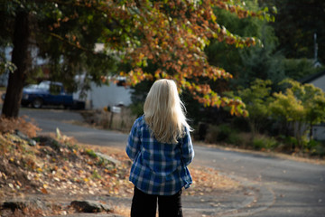 Fototapeta premium 10 year old boy with long blond hair walking down the street