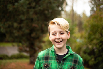 Portrait of happy boy outdoors wearing in a green plaid flannel