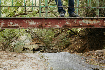 legs of  man on old metal bridge. Side view