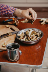 Hand pouring sliced mushrooms in bowl