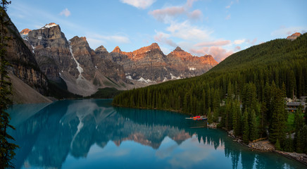 Beautiful Panoramic view of an Iconic Famous Place, Moraine Lake, during a vibrant summer sunrise. Located in Banff National Park, Alberta, Canada.