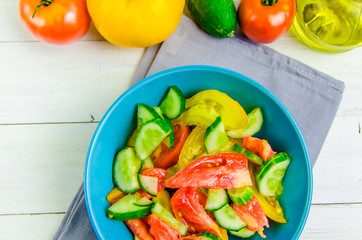 summer salad with cucumbers and tomatoes on white background