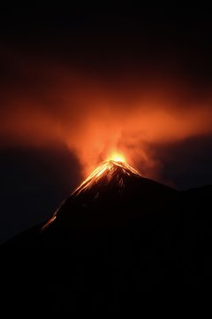 Erupting volcano under a dark sky