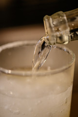 瓶酎ハイを注ぐ様子。塩が塗られたグラス。焼酎