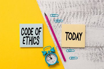 Word writing text Code Of Ethics. Business photo showcasing basic guide for professional conduct and imposes duties Notepads marker pen colored paper sheet alarm clock wooden background