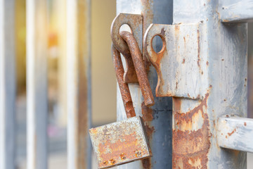 Selective focus of Old master key with rust unlocked on old aluminum fence, Security concepts