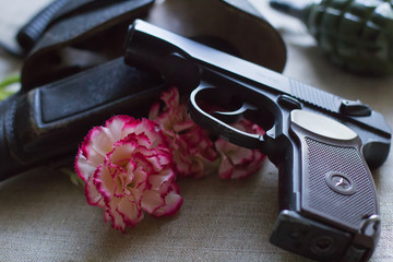 A gun next to a flower
