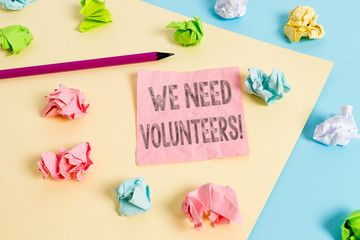 Conceptual hand writing showing We Need Volunteers. Concept meaning someone who does work without being paid for it Colored crumpled papers empty reminder blue yellow clothespin