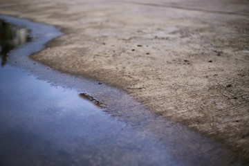 concrete road and flooding water. poor drainage system left puddle of inundated rain storm water on street surface