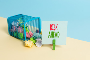 Text sign showing Risk Ahead. Business photo showcasing A probability or threat of damage, injury, liability, loss Trash bin crumpled paper clothespin empty reminder office supplies tipped