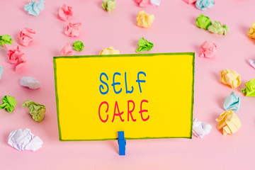 Word writing text Self Care. Business photo showcasing the practice of taking action to improve one s is own health Colored crumpled papers empty reminder pink floor background clothespin