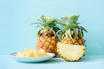 Fototapeta na wymiar Sliced pineapple on white dish and pineapple fruit on pastel background