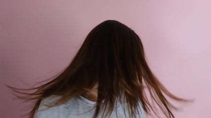 Young pretty woman with long hair shaking her head isolated over pink background. People sincere emotions lifestyle.