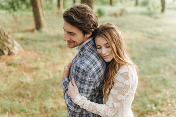 A young couple of brides walking in the pine forest