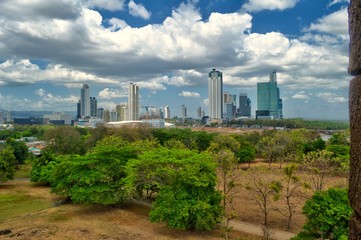 Fototapeta na wymiar Vista panorámica del horizonte moderno de la ciudad de Panamá con modernos edificios de gran altura. Vista desde el viejo Panamá con una zona boscosa y rocosa en primer plano.