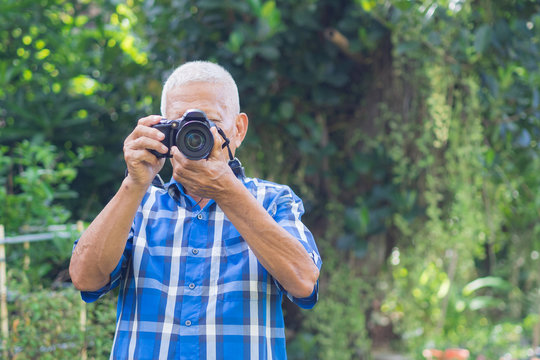 Senior man using a digital camera to take photo