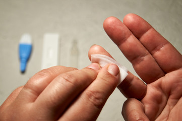 Close up of woman hands, cleaning the finger with an alcohol pad for express HIV test