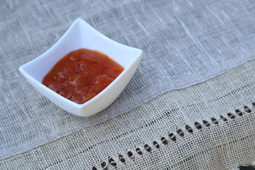 Saucer with jam on a linen tablecloth