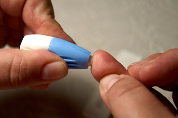 Close up of woman hands using lancet on finger to check HIV status. Blue lancet. Hiv test express.