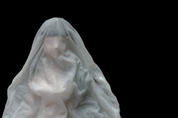 Long black hair doll cover with white sheet drown in water on dark background. Minimal Halloween scary concept.