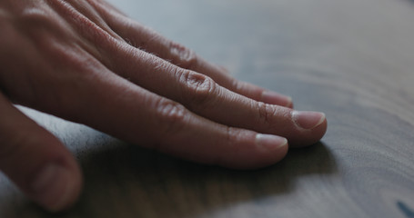 Fototapeta premium closeup man hand checking untrated black walnut solid board