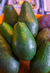 Ripe green avocado close-up on a market counter.