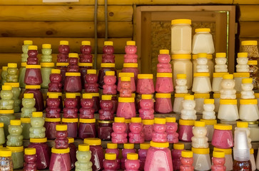 Fototapeta premium different honey in plastic cans stands on a wooden counter in the room