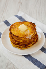 Homemade corn meal Johnny cakes with butter on a white plate, low angle view. Close-up.