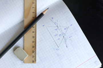 pencil, wash, ruler and checkered notebook with a pattern of light refraction patterns top view. studying physics at school