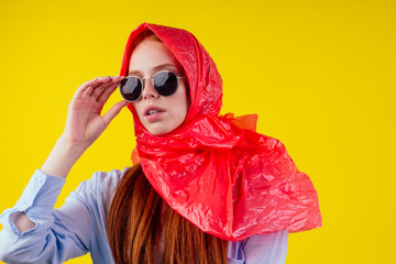 beautiful redhaired ginger stylish woman wearing red plastic polyethylene package on her head and...