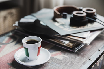 Italy cup of coffee with vinyl records and headphones on table in living room