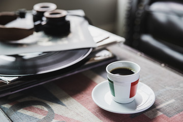 Italy cup of coffee with vinyl records and headphones on table in living room