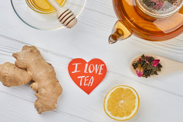 I love TEA concept. Teapot, honey, lemon, ginger root, spoon with dry tea and heart-shaped paper...