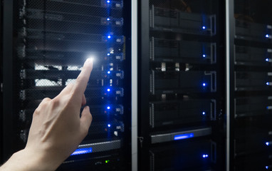 Finger pressing on server room datacenter background. Technology background.