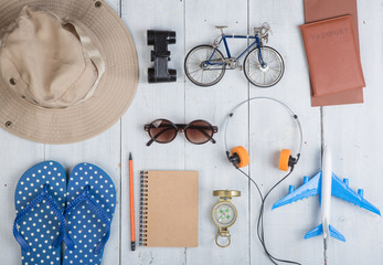Prepare for journey - accessories and travel items, packing clothes: hat, passport, tickets, model of airplane and bicycle, flip flops, sunglasses, compass