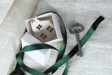 open gift with a model of the house inside and a key lying next to the table top view. big wedding surprise in a small box
