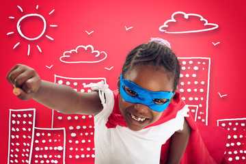 Child acts like a superhero to save the world on red background