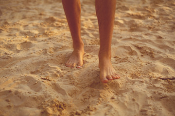 bare male feet walk on the sandy beach, healthy yoga practice concept