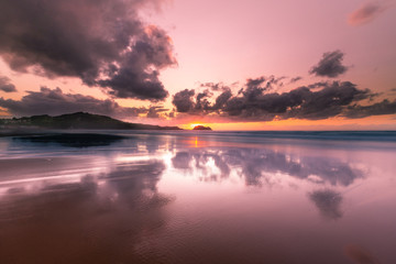 Light reflections at Zarautz beach with the mouse of Getaria at the bottom in a summer sunset.