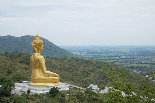 Golden Buddha statue  on mountain with sky background