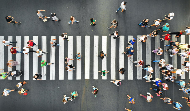 Aerial. People crowd motion on pedestrian crosswalk. Top view from drone.