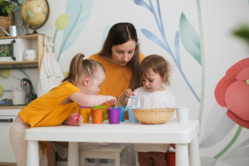 Caucasian mother studies colors with two children