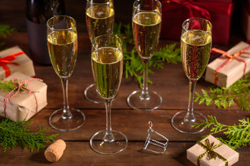 Christmas holiday table with glasses and a bottle of wine of champagne. Eve of new year, preparation and laying of a wooden holiday table