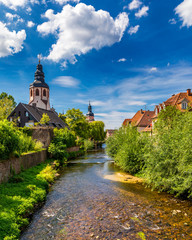 Old city of Ettlingen in Germany with a river and a church. View of a central district of Ettlingen, Germany, with a river and a bell tower of a church. Ettlingen, Baden Wurttemberg, Germany. - obrazy, fototapety, plakaty