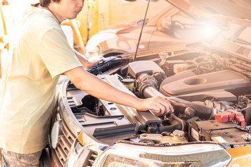 Automotive mechanic checking and repair car in garage.