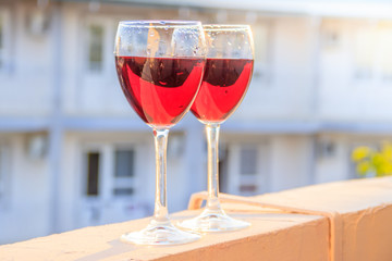 Two glasses of red wine are backlit by the sun. Grape drink.