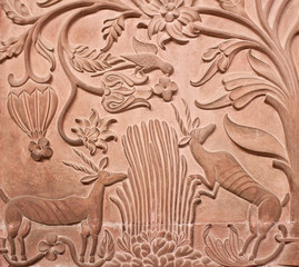 Fototapeta na wymiar Ancient bas-relief with flowers and hunting animals in Junagarh fort in Bikaner, Rajasthan, India