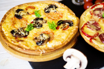 Hot homemade pepperoni pizza on white wooden table and black stone surface. Ready to eat