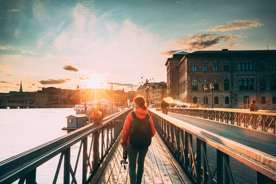 Stockholm, Sweden. Young Caucasian Woman Lady Tourist Traveler Walking On Famous Skeppsholmsbron - Skeppsholm Bridge. Popular Place, Landmark And Destination In Stockholm, Sweden