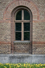 Old decrepit arched wooden window on the facade
